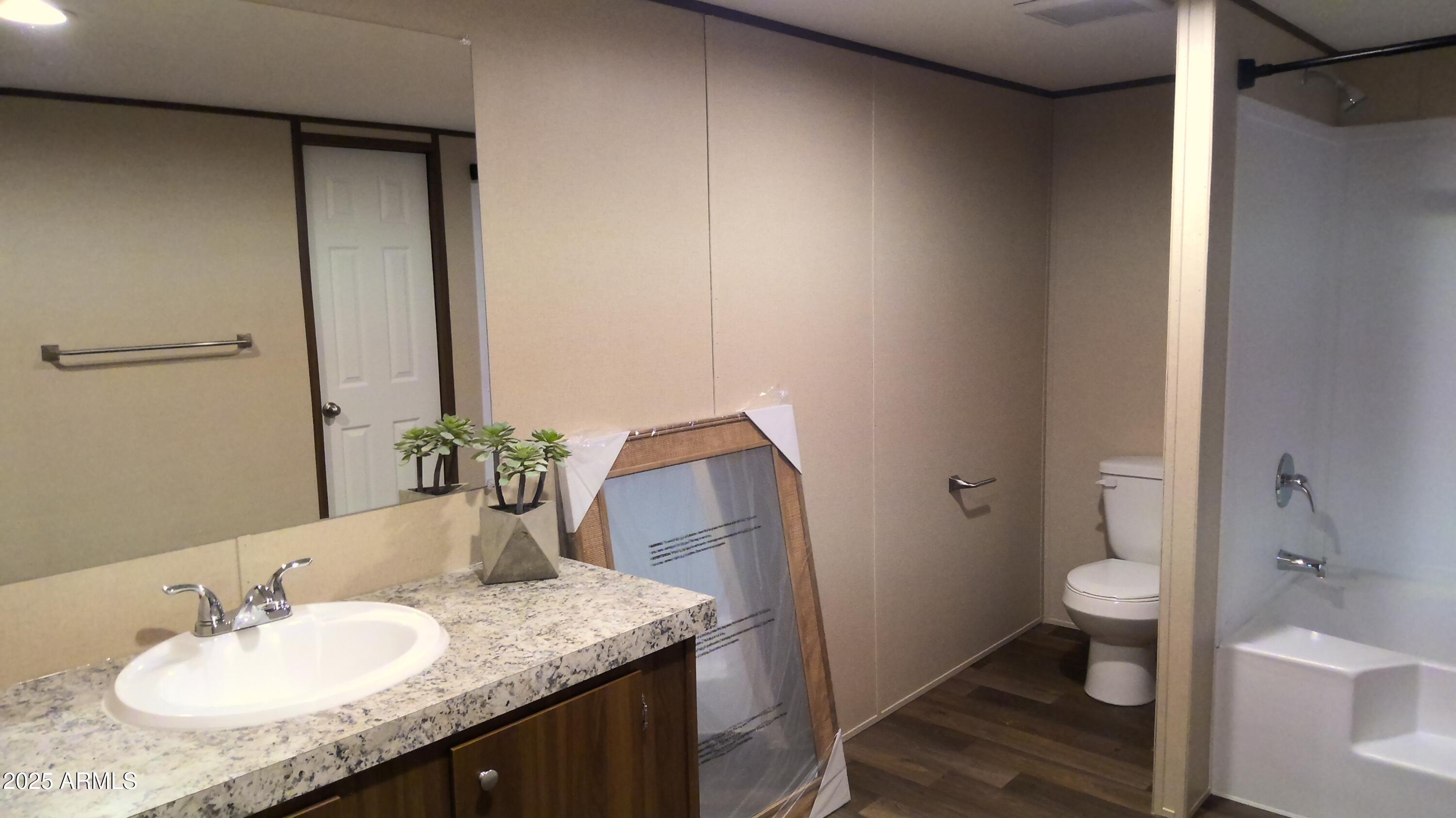51603 West Pony Road Maricopa, AZ 85139 - Photo 27 of 36 a bathroom with a granite countertop sink toilet and shower