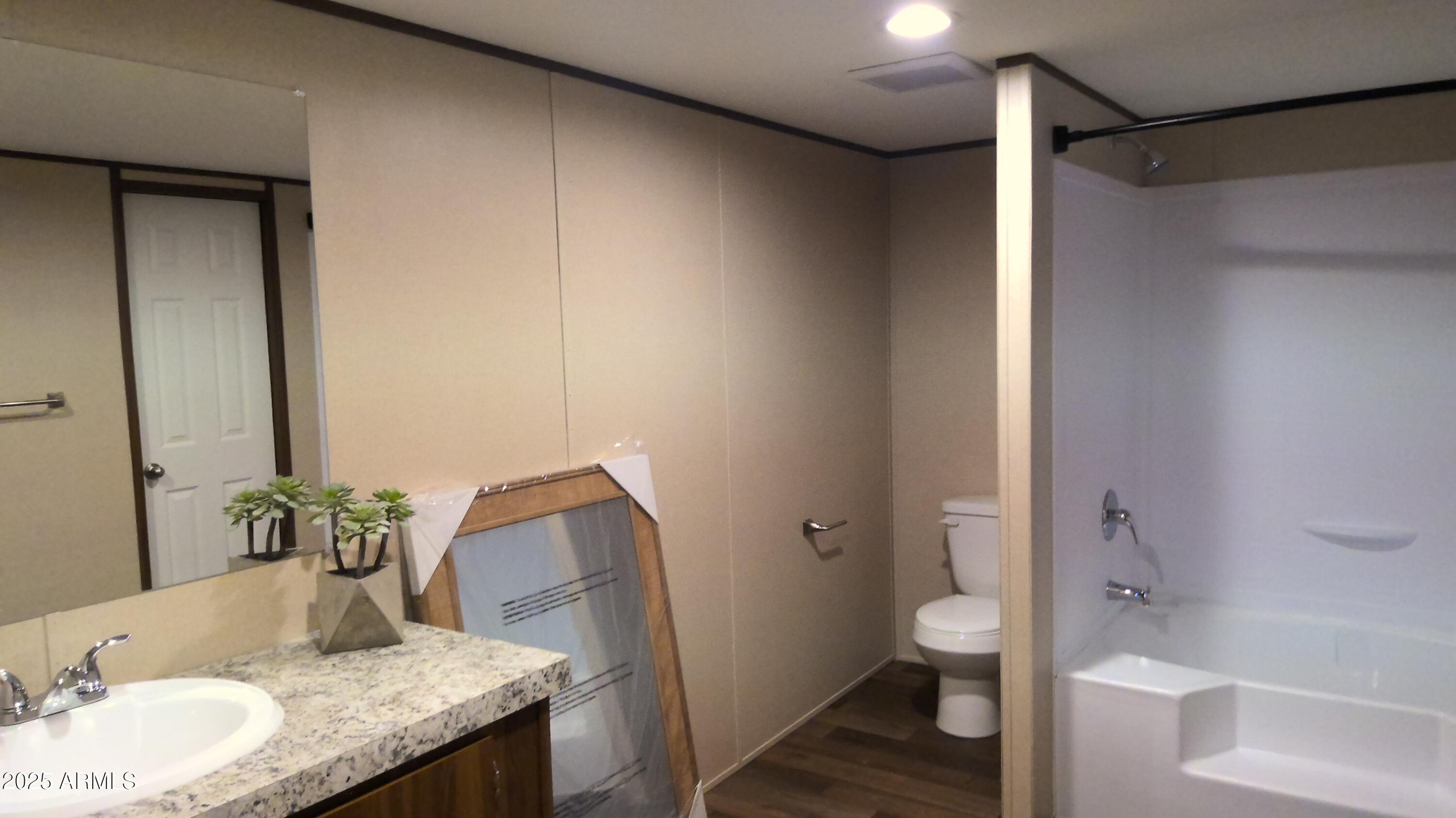 51603 West Pony Road Maricopa, AZ 85139 - Photo 28 of 36 a bath room with a granite countertop sink and a mirror