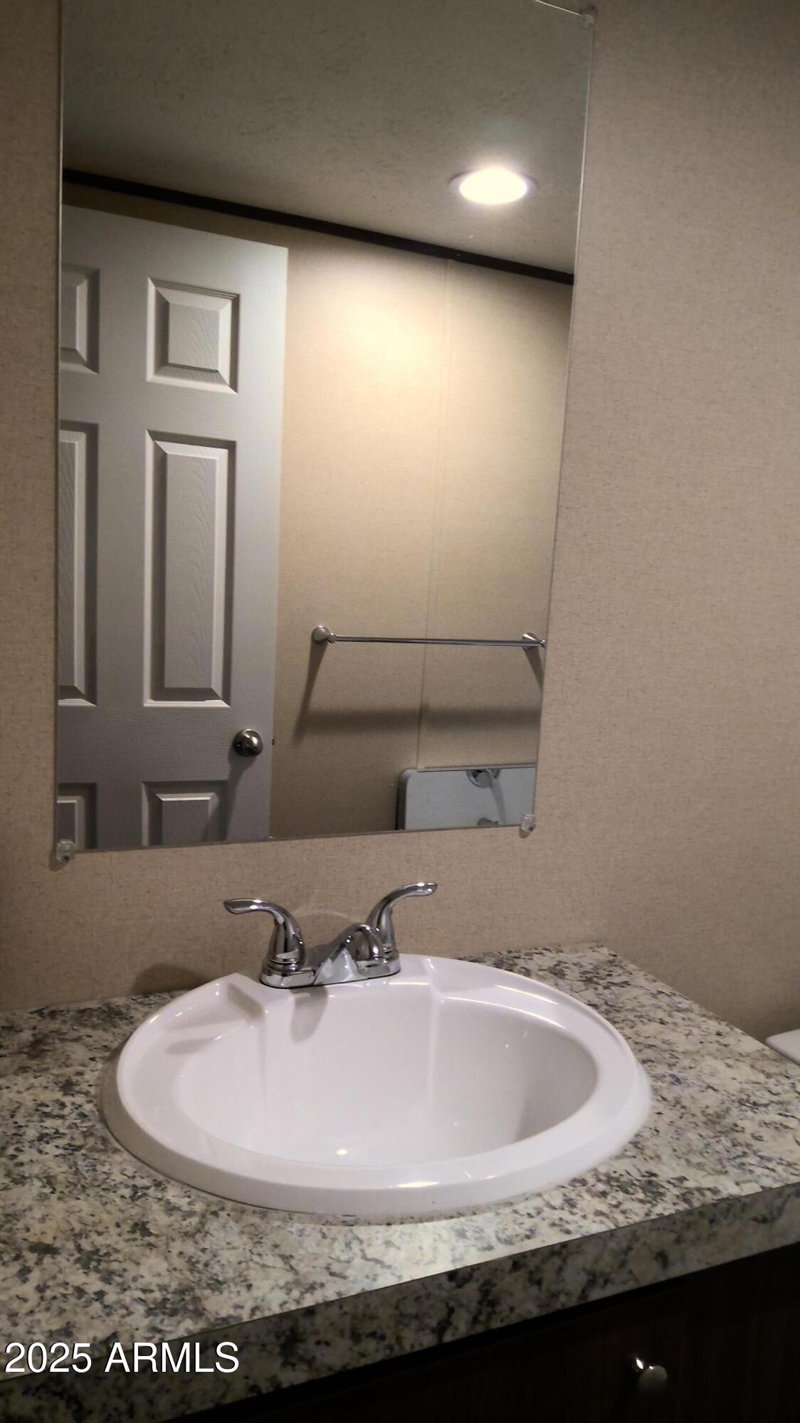 51603 West Pony Road Maricopa, AZ 85139 - Photo 35 of 36 a bathroom with a granite countertop sink and mirror