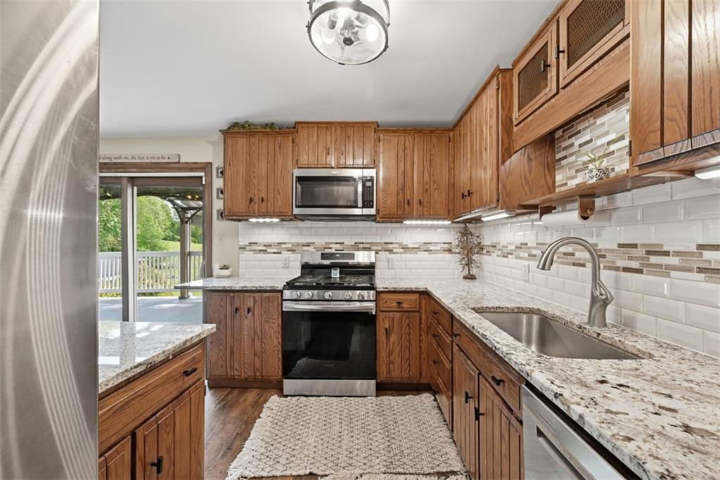 108 Connoquenessing School Road Connoquenessing, PA 16027 - Photo 13 of 50 a kitchen with stainless steel appliances granite countertop a sink stove microwave and refrigerator