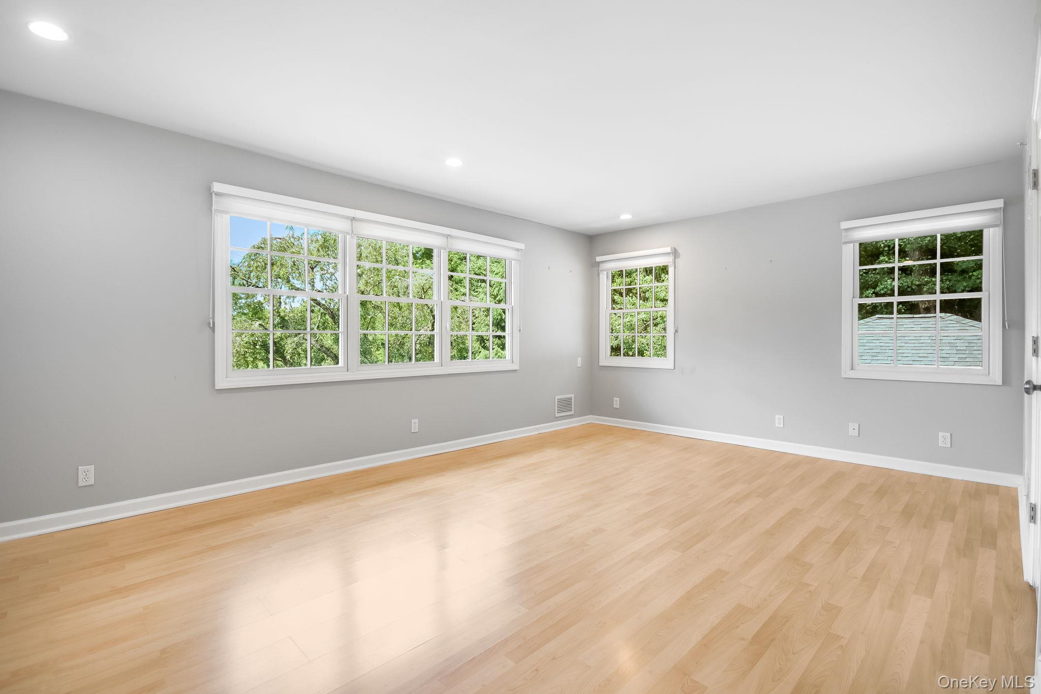 26 Century Ridge Road Purchase, NY 10577 - Photo 15 of 50 Primary en-suite (split level up); bright room featuring extensive natural light from multiple windows, recessed ceiling lighting, light wood-finish flooring, and light gray walls.