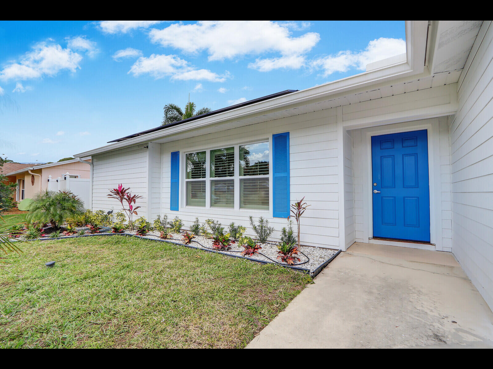 609 Oak Terrace Jupiter, FL 33458 - Photo 3 of 28 a front view of a house with a garden