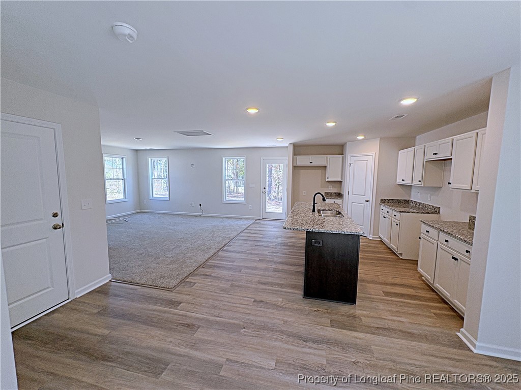 18 Morgan Court Spring Lake, NC 28390 - Photo 5 of 16 a large kitchen with kitchen island a sink a stove a refrigerator and white cabinets