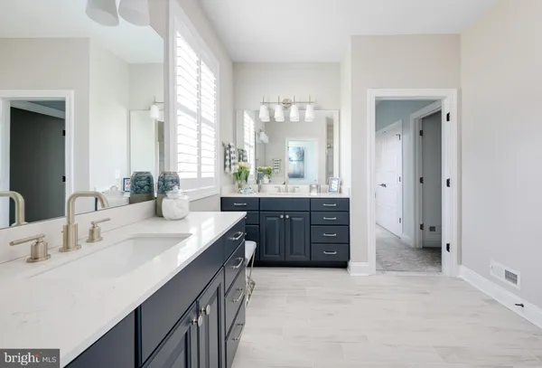 a bathroom with a double vanity sink double mirror and a window