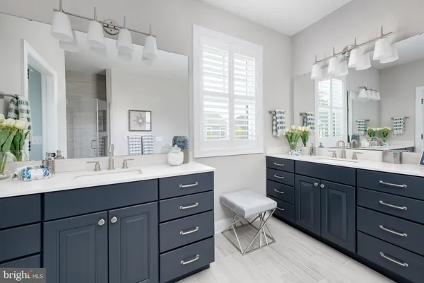 a bathroom with a double vanity sink toilet and shower