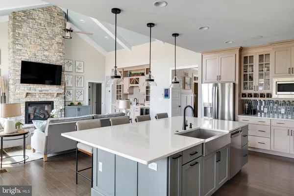a kitchen with stainless steel appliances kitchen island granite countertop a table chairs stove and white cabinets