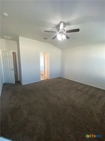 a view of an empty room with a chandelier fan