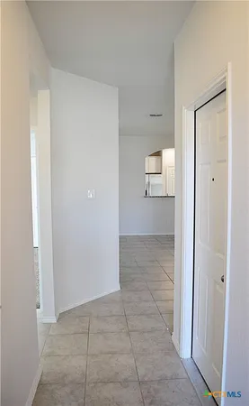 an empty room with wooden floor cabinet and a window