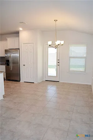 a kitchen with stainless steel appliances granite countertop a refrigerator stove and white cabinets