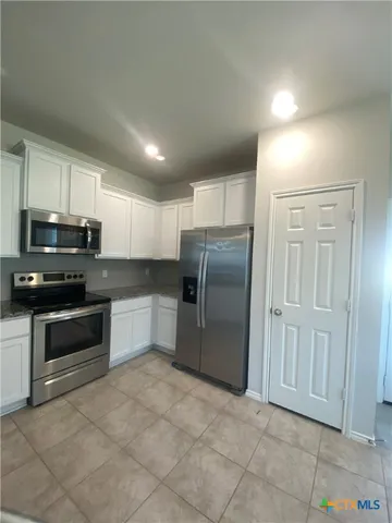 a large kitchen with granite countertop a stove and a sink