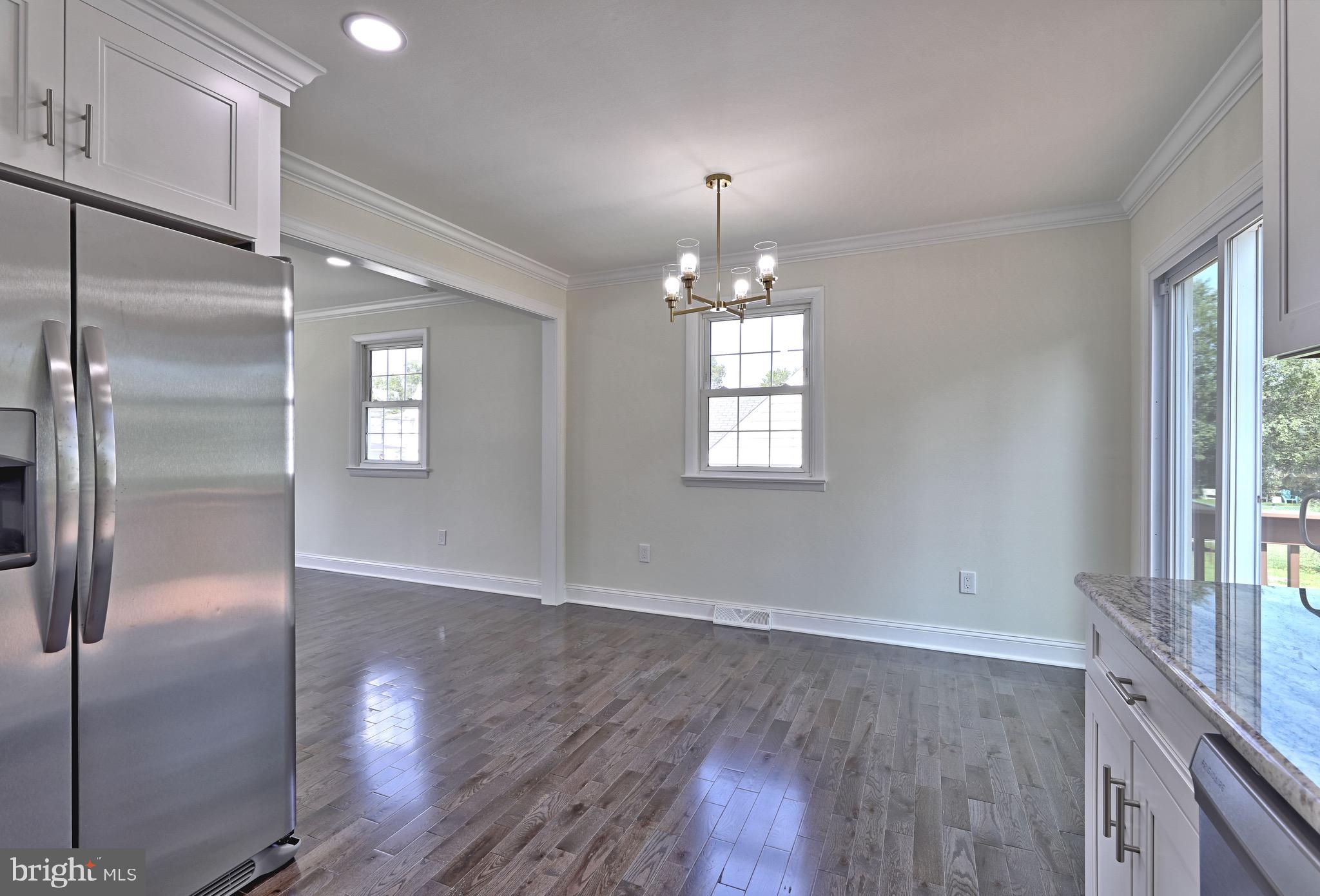 620 Arndt Avenue Riverside, NJ 08075 - Photo 12 of 22 a view of an empty room with wooden floor kitchen view and a window
