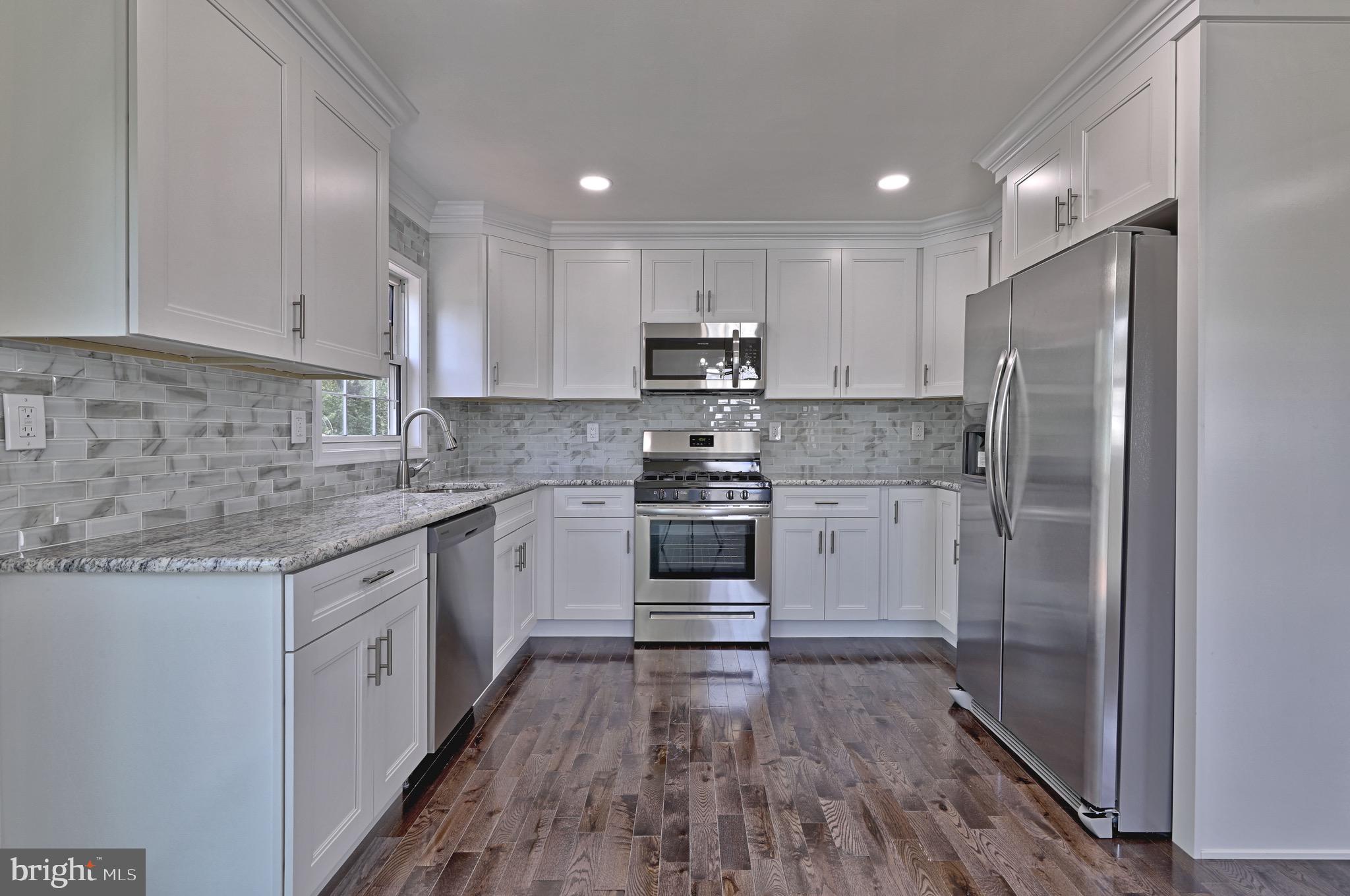620 Arndt Avenue Riverside, NJ 08075 - Photo 8 of 22 a kitchen with a white cabinets and wooden floor