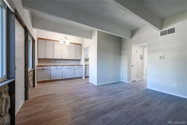 a view of a kitchen with wooden floor and electronic appliances