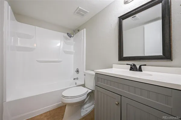 a bathroom with a toilet a sink a mirror and vanity
