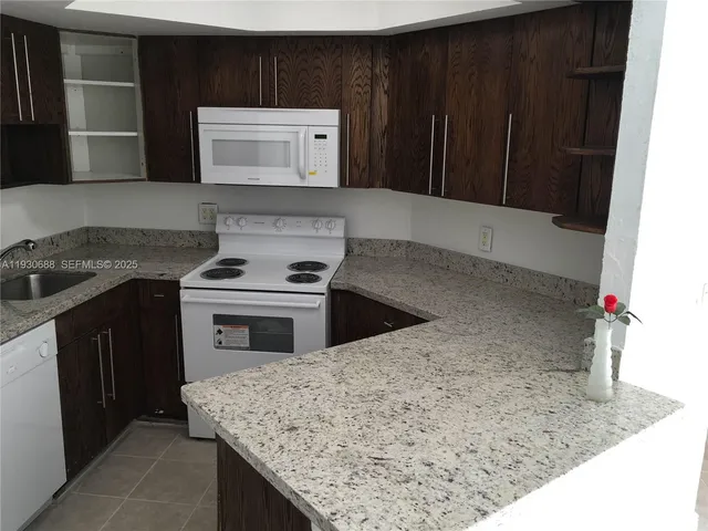 a kitchen with granite countertop a stove and a microwave