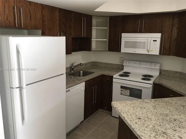 a kitchen with a stove a refrigerator and a sink
