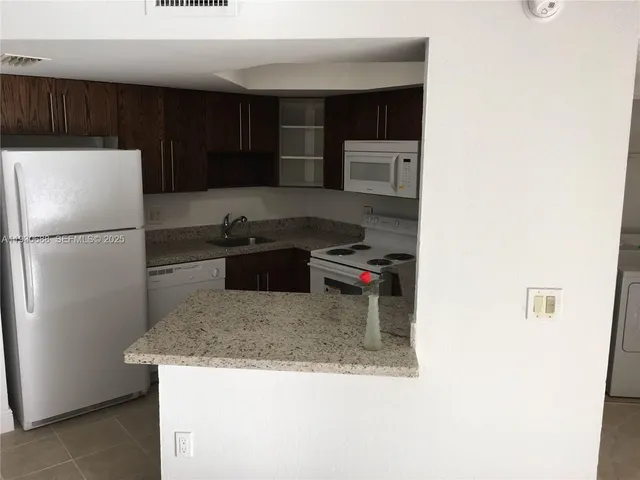 a kitchen with a refrigerator sink and cabinets