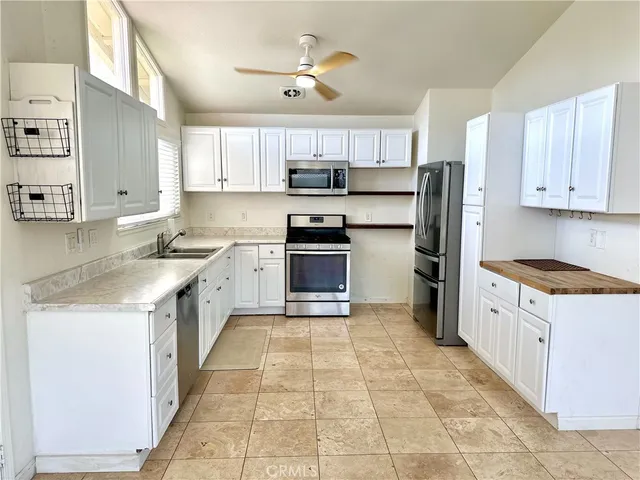 a kitchen with granite countertop a sink a counter top space stainless steel appliances and cabinets