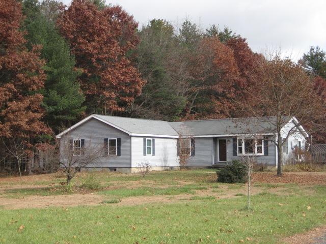 a view of a yard in front of a house with large trees
