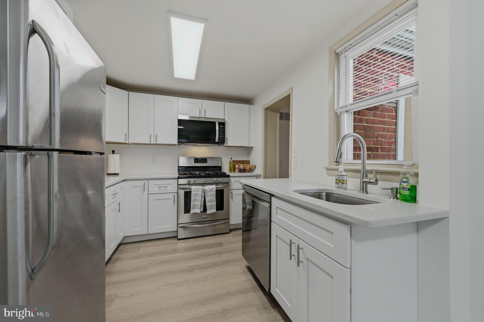 208 Harding Avenue Wilmington, DE 19804 - Photo 16 of 28 a kitchen with white cabinets and stainless steel appliances