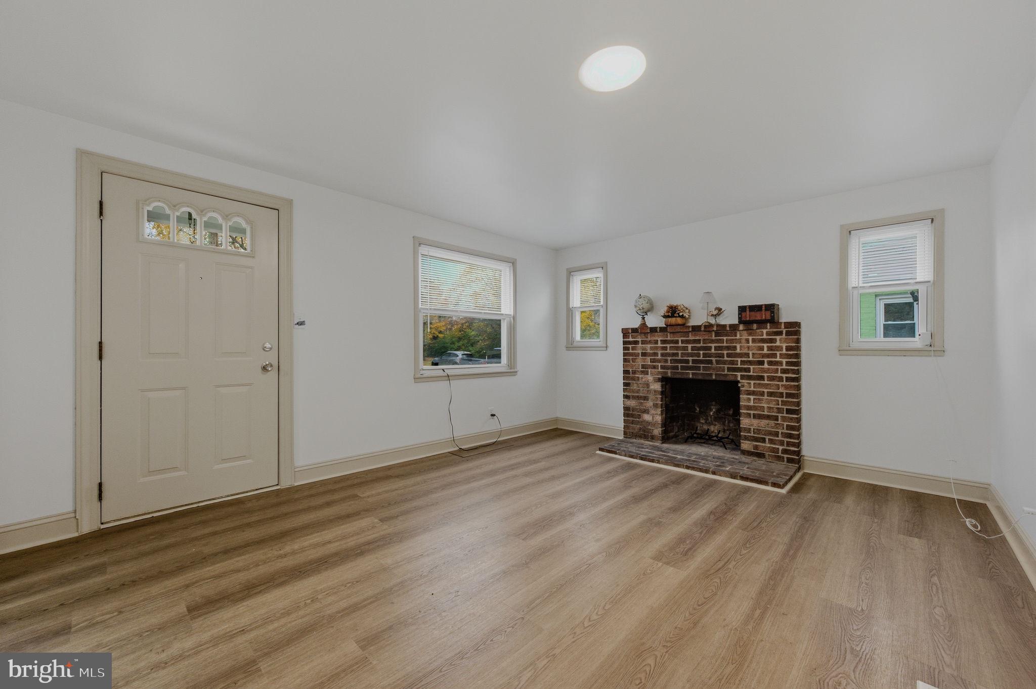 208 Harding Avenue Wilmington, DE 19804 - Photo 6 of 28 an empty room with windows fireplace and wooden floor