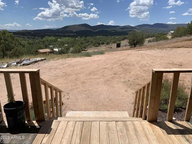 a kitchen with stainless steel appliances granite countertop a refrigerator a sink dishwasher a stove and a dining table with wooden floor