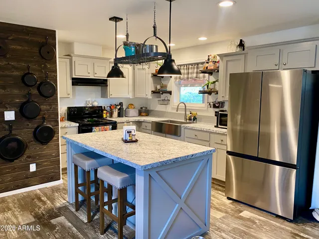 a kitchen with stainless steel appliances kitchen island granite countertop a sink and cabinets