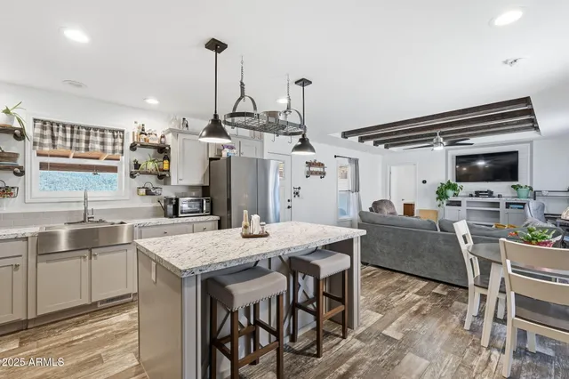 a kitchen with stainless steel appliances granite countertop a refrigerator a stove a sink and a counter top space