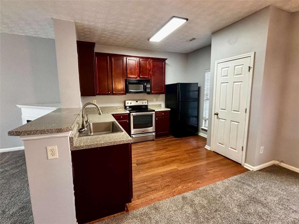 4249 High Park Lane East Point, GA 30344 - Photo 9 of 27 a kitchen with stainless steel appliances granite countertop a stove refrigerator sink and microwave