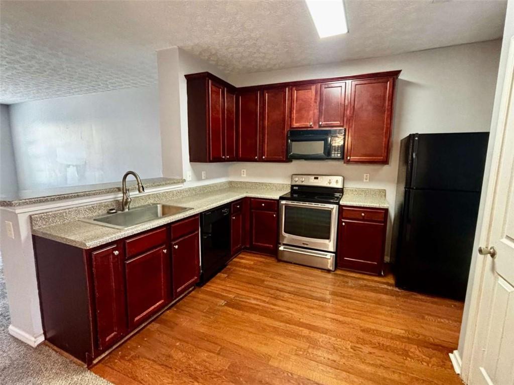 4249 High Park Lane East Point, GA 30344 - Photo 10 of 27 a kitchen with wooden cabinets a sink and stainless steel appliances