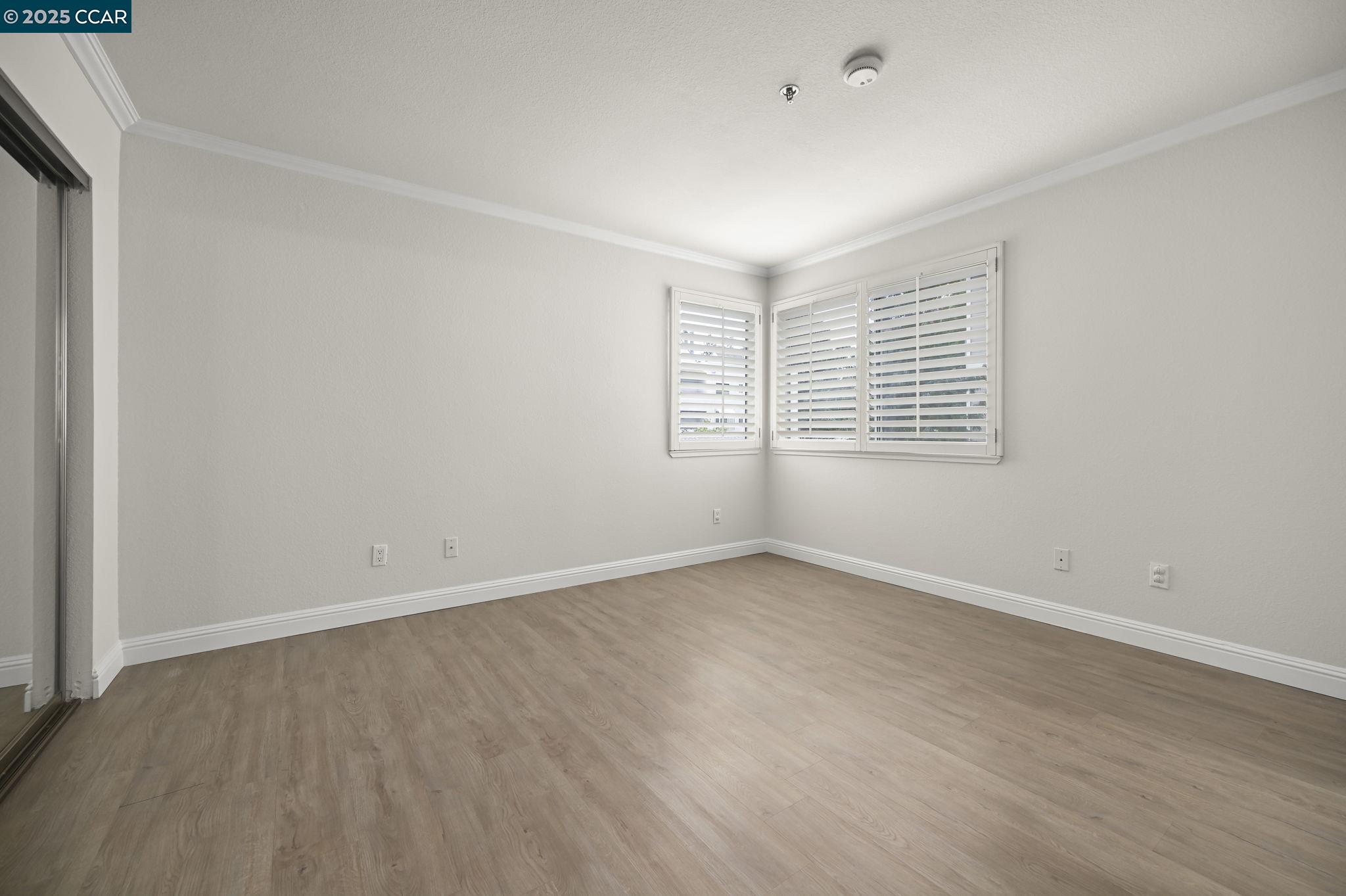 2550 Oak Road, Unit 209 Walnut Creek, CA 94597 - Photo 16 of 34 an empty room with wooden floor and windows