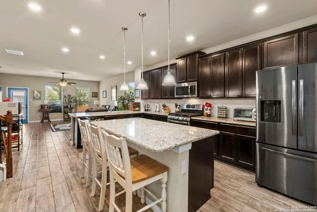 a kitchen with stainless steel appliances granite countertop a refrigerator a sink and a stove