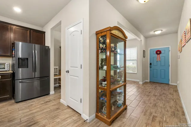a view of kitchen with stainless steel appliances granite countertop a refrigerator and a stove top oven