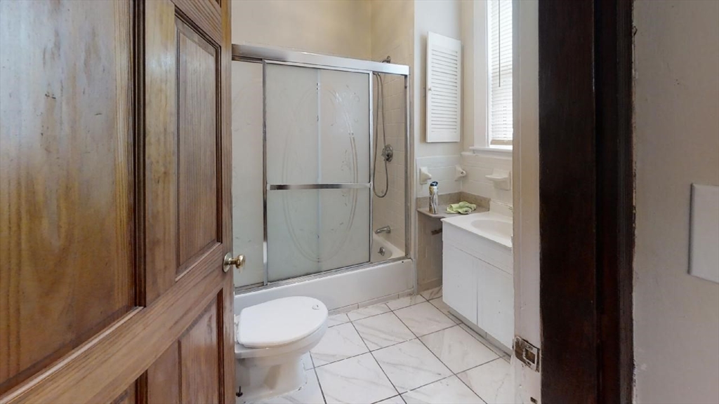 33 Bellingham Street, Unit 2 Chelsea, MA 02150 - Photo 11 of 18 a bathroom with a granite countertop sink a toilet a mirror and shower