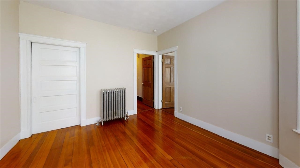 33 Bellingham Street, Unit 2 Chelsea, MA 02150 - Photo 15 of 18 an empty room with wooden floor and closet