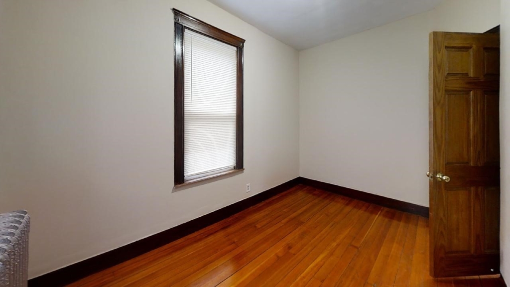 33 Bellingham Street, Unit 2 Chelsea, MA 02150 - Photo 18 of 18 a view of an empty room with wooden floor and a window