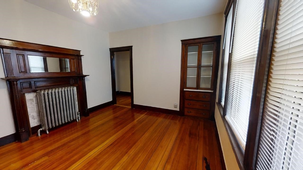 33 Bellingham Street, Unit 2 Chelsea, MA 02150 - Photo 4 of 18 an empty room with wooden floor and windows