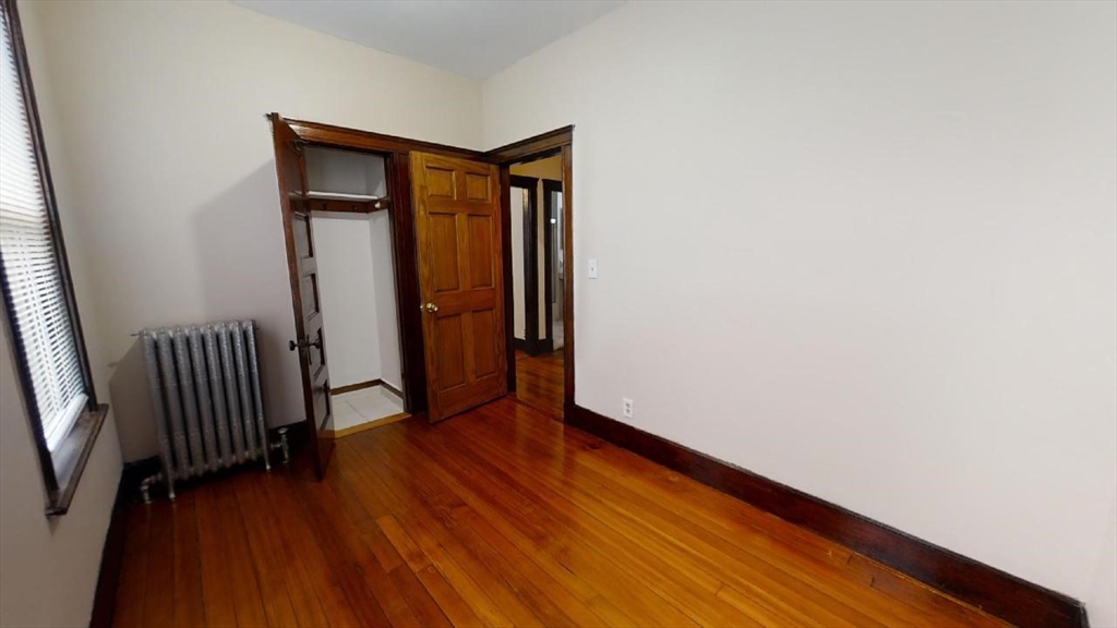 33 Bellingham Street, Unit 2 Chelsea, MA 02150 - Photo 5 of 18 an empty room with wooden floor and windows