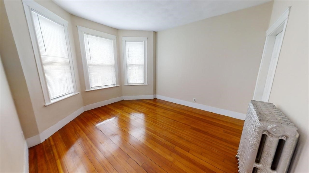 33 Bellingham Street, Unit 2 Chelsea, MA 02150 - Photo 7 of 18 an empty room with wooden floor and windows