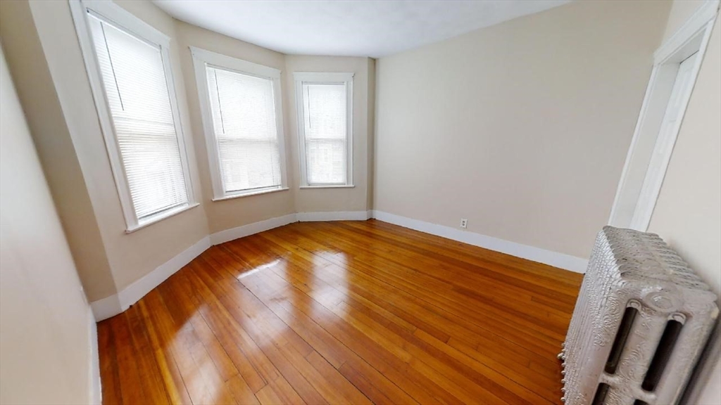 33 Bellingham Street, Unit 2 Chelsea, MA 02150 - Photo 9 of 18 an empty room with wooden floor and windows