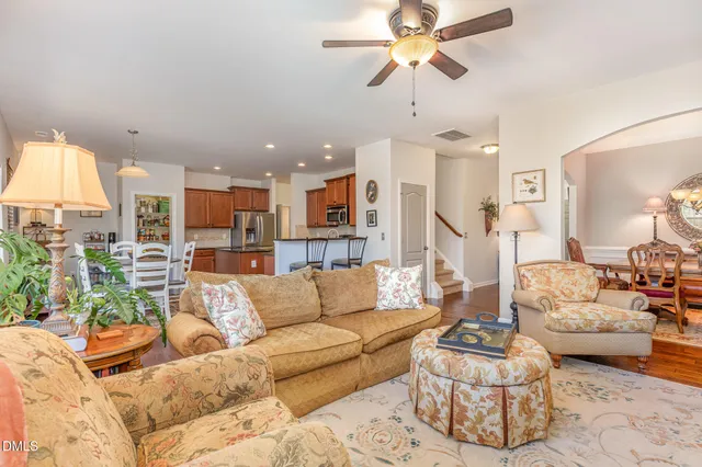 a living room with furniture kitchen view and a large window