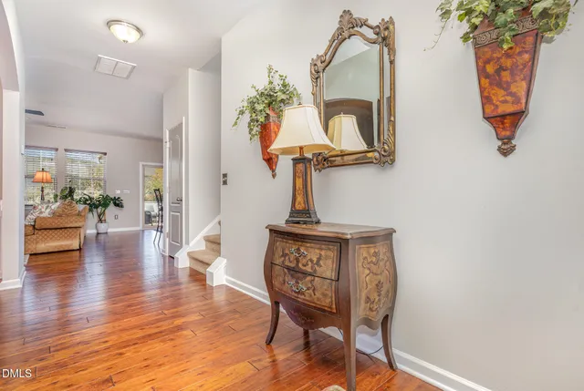 a view of a hallway with wooden floor and furniture