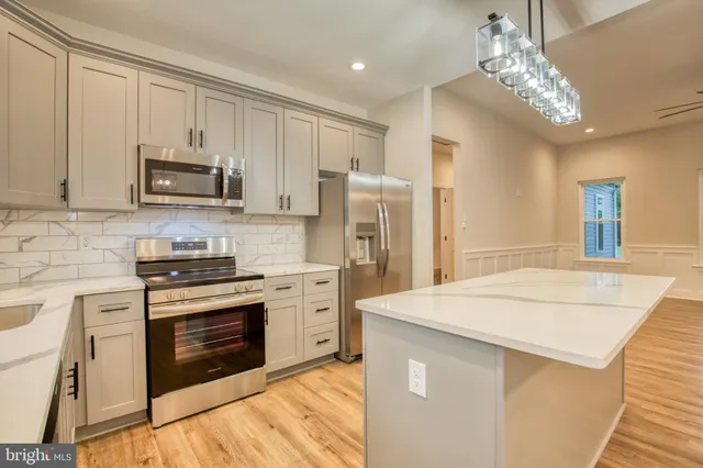 a kitchen with stainless steel appliances granite countertop a stove top oven a refrigerator and a stove