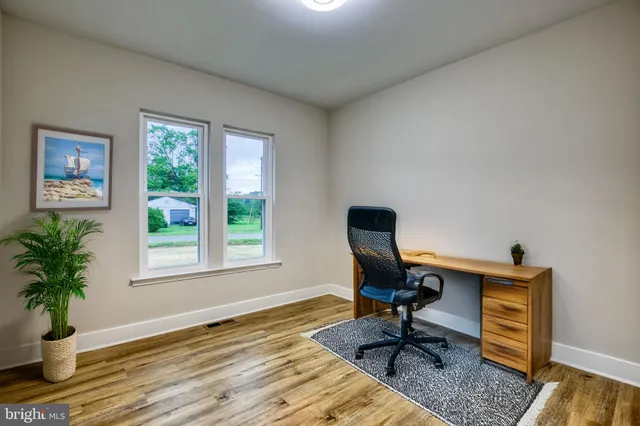 a view of a workspace with furniture and a window