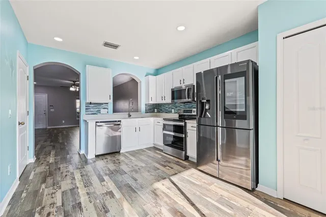a kitchen with granite countertop a refrigerator and a sink