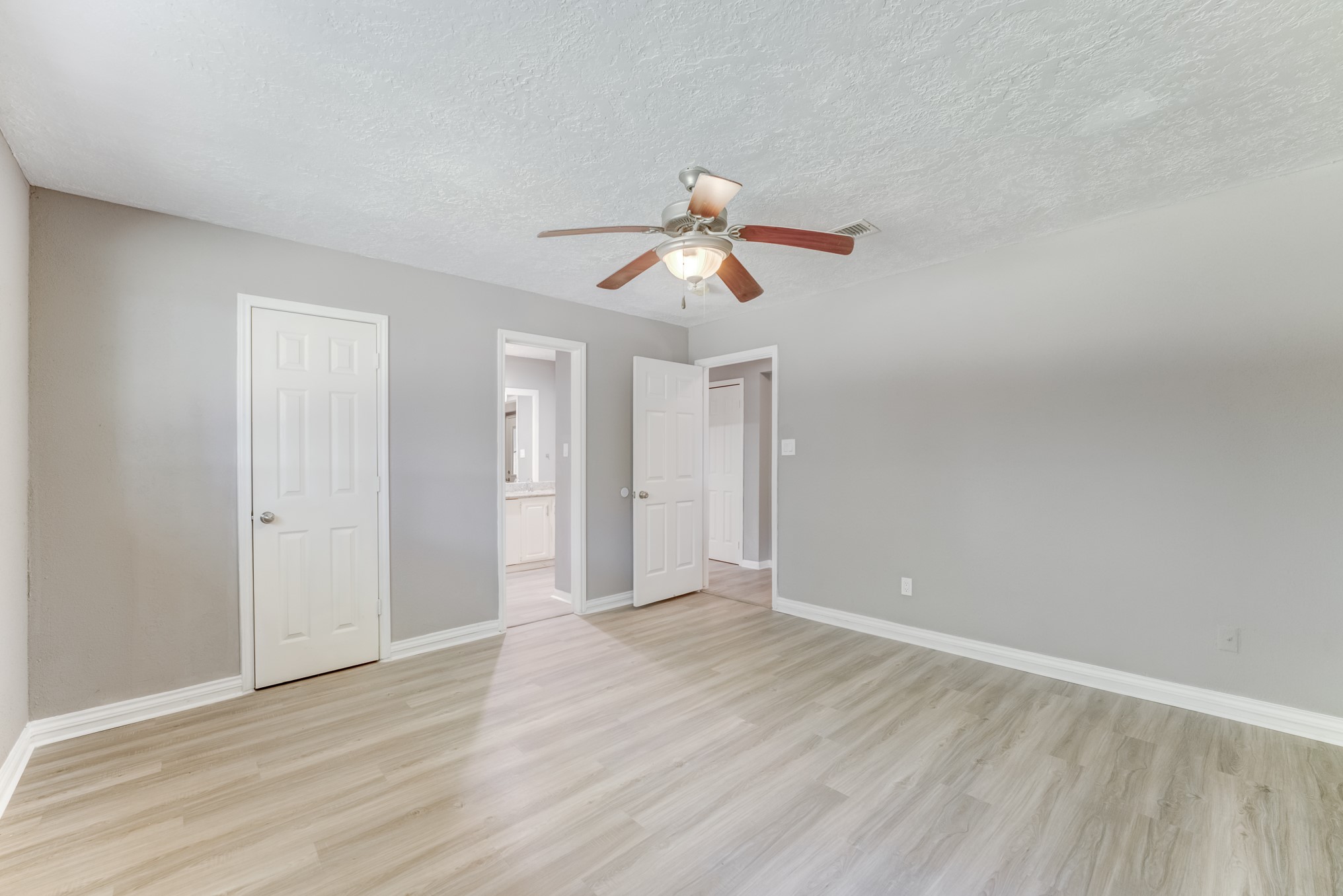 81 Oak Grove Lane Conroe, TX 77304 - Photo 17 of 50 a view of a room with wooden floor and a ceiling fan