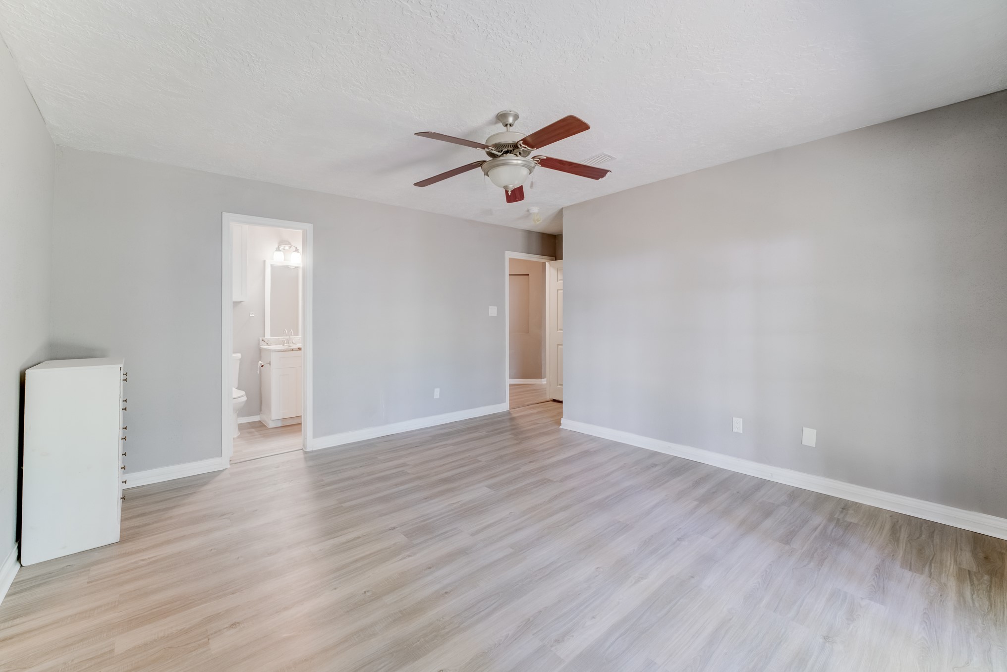 81 Oak Grove Lane Conroe, TX 77304 - Photo 20 of 50 a view of an empty room with wooden floor and a ceiling fan