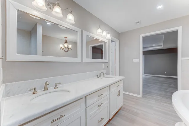 a spacious bathroom with a double vanity sink and a mirror