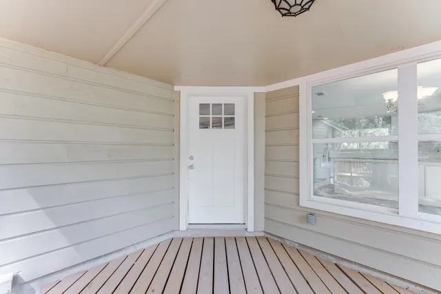 a view of a hallway with wooden floor and a window