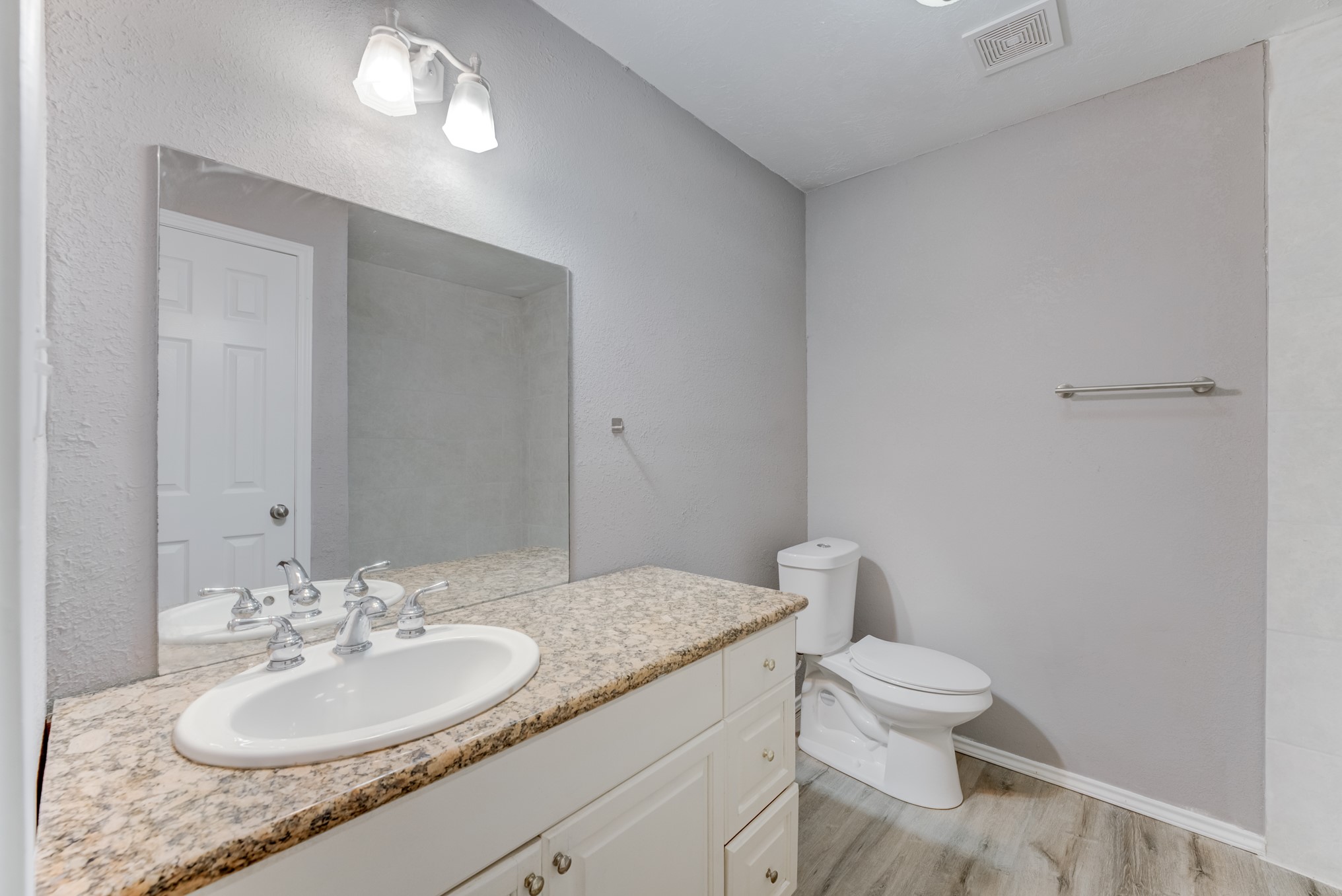 81 Oak Grove Lane Conroe, TX 77304 - Photo 39 of 50 a bathroom with a granite countertop sink a toilet and a mirror